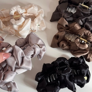 Flat lay of large satin hair claw clips in beige, grey, brown and black colors