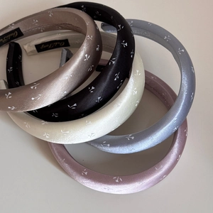 Détail de serre-têtes en satin rembourrés avec imprimé floral délicat et texture soyeuse