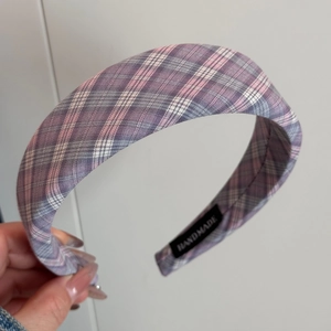 Detail of purple plaid padded headband showing handmade label and non-slip inner lining