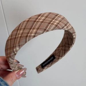 Detail showing the inner black handmade tag on a brown plaid vintage headband