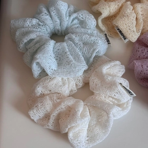 Λεπτομερής κοντινή λήψη δαντελωτών scrunchies σε παστέλ χρώματα με υφαντή ετικέτα
