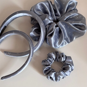 Détail d'un ensemble de serre-tête et chouchou en satin bleu argenté à fleurs
