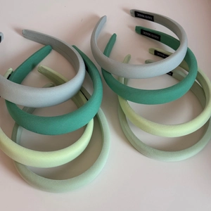 Detail of assorted green sponge headbands with handmade label and woven texture