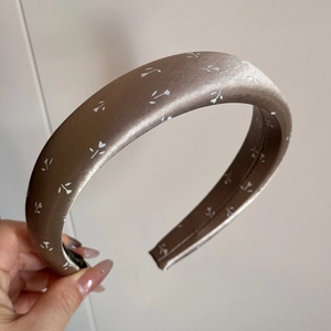 Vue détaillée du serre-tête en satin marron à fleurs avec un design large et élégant
