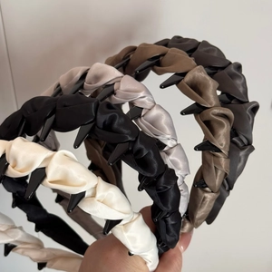 Détail de la texture satinée du serre-tête avec plis de tissu et dents antidérapantes