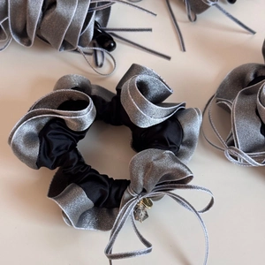 Detailed view of ruffle satin hair scrunchies with bow ribbons and crystal pendants