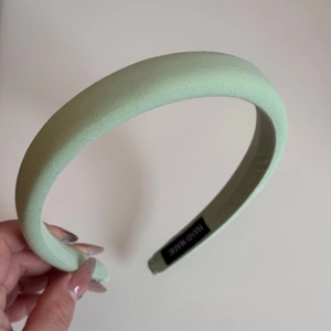 Detail of mint green padded sponge headband with handmade label and twill fabric texture