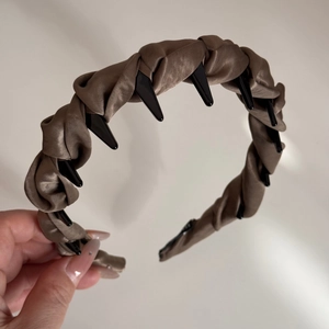 Vue détaillée du serre-tête en satin marron avec des dents antidérapantes internes