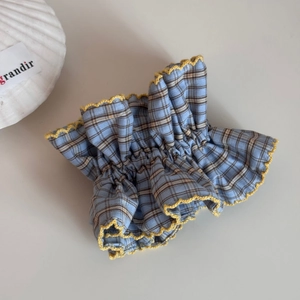 Detail view of blue and brown checkered scrunchie with yellow crocheted lace edge