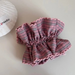 Detail of pink plaid scrunchie with lace trim and shell decoration on white background
