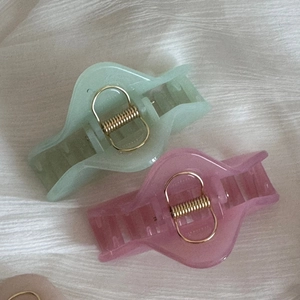 Gros plan de pinces à cheveux triangulaires mates semi-transparentes vert et rose