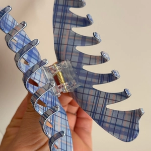 Detail of blue plaid large hair claw clip with golden metal spring for thick hair