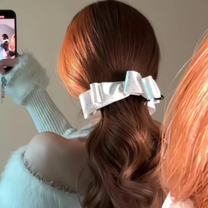 White satin multi-layered bow hair clip with silver dots on female ponytail