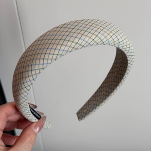 Détail de l'étiquette tissée fait main à l'intérieur du serre-tête en tissu à carreaux