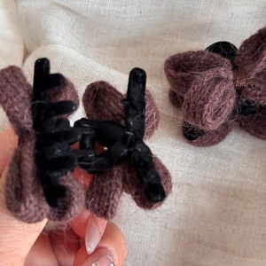 Détail de barrettes nœuds en tricot marron avec texture en laine et pinces en plastique