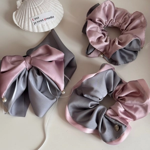 Detailed view of satin bow hair clip and scrunchies with elegant pearl pendants
