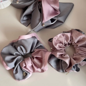 Three-piece satin scrunchie set with pearl charms and elegant silk texture in grey and pink