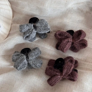 Lot de 4 élastiques nœuds en laine tricotée grise et taupe sur un fond en lin beige naturel