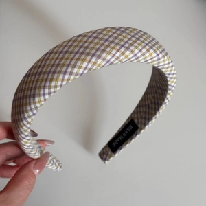 Detail shot of a handmade lavender plaid fabric hairband with a premium woven texture