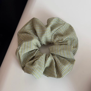 Détail du chouchou en tissu à carreaux vert et jaune avec texture en coton doux