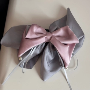 Detailed macro view of satin scrunchie fabric texture with elegant faux pearl pendant