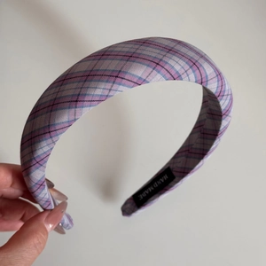 Detail of lavender plaid fabric headband showing the HAND MADE woven label and texture