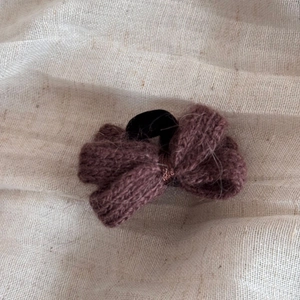 Gros plan sur un nœud de cheveux en laine rose montrant la texture douce du tricot fait main