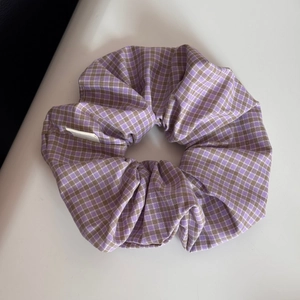Detailed close-up of purple and brown checkered fabric scrunchie with soft cotton texture