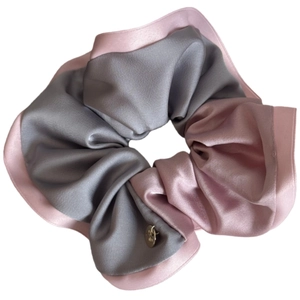 Elegant satin scrunchie in grey and pink dual-tone design with a metallic charm
