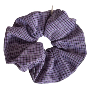Elegant purple checkered fabric scrunchie with soft pleated texture on white background