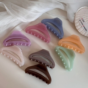 Lot de pinces à cheveux en résine aux tons Morandi présentées sur un fond en tissu blanc