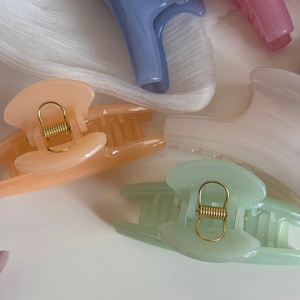 Detail of candy-colored resin hair claws with strong golden metal springs for thick hair