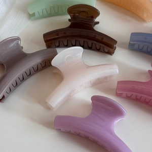 Close-up of assorted candy-colored resin hair claws in coffee, cream, and lavender shades