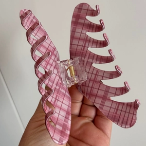 Close-up of pink checkered claw clip showing durable spring hinge and translucent texture