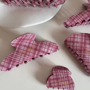 Detail of pink plaid pattern acetate shark hair clips in long and heart shapes