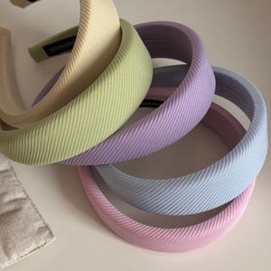 Macro shot of five pastel macaron colored sponge headbands with fine ribbed fabric texture