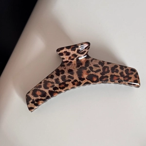 Gros plan sur la pince à cheveux léopard en résine brillante avec de grandes dents