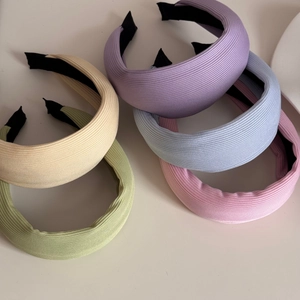 Détail de cinq serre-têtes en maille côtelée colorée montrant la texture douce et large