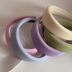 Detailed macro view of macaron colored sponge headbands with handmade label and striped texture