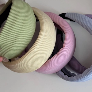 Gros plan de serre-têtes en tricot côtelé épais en vert pastel, beige, rose et bleu