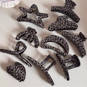 Close-up of various leopard print hair clips in heart and star shapes with gold hardware