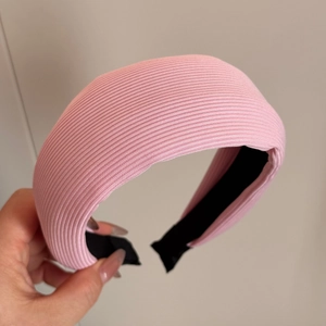 Détail d'un serre-tête rose en maille côtelée avec texture épaisse et doublure intérieure