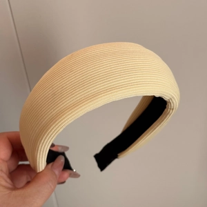 Vue détaillée de la texture tricotée crème sur un bandeau large rembourré élégant