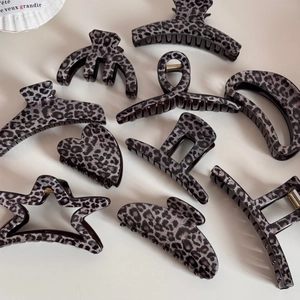 Elegant grey leopard print hair claw set in heart and star shapes on beige background