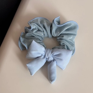 Close-up detail of the light blue lace polka dot hair scrunchie with a large bow decoration