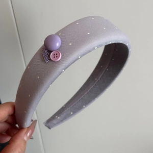 Detail of purple polka dot scrunchie with handmade metal tag and decorative buttons
