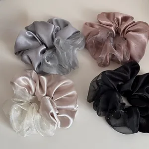 Detailweergave van grote satijnen en organza scrunchies in grijs, roze, beige en zwart