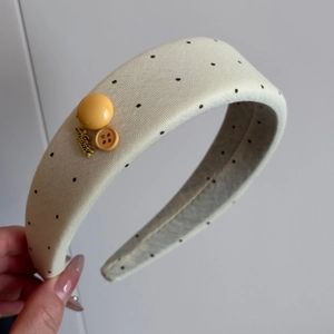 Detail of cream lace scrunchie with black polka dots and hand made metal charm