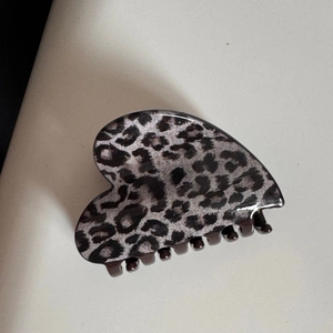 Detail shot of heart-shaped leopard print hair claw clip in dark grey and black resin