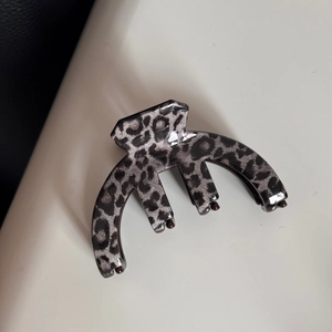 Macro shot of stylish leopard print hair claw clip with glossy finish and thick teeth